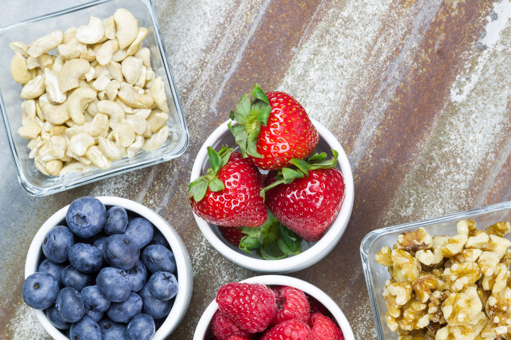 Healthy fruit and nut snacks that are good for weight loss including  strawberries, blueberries, raspberries, walnuts, and cashews.